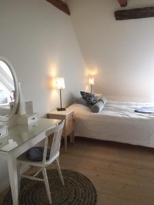 una camera con letto, specchio e scrivania di Munkagården Bed & Breakfast a Svalöv