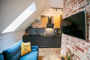 salon z niebieską kanapą i ceglaną ścianą w obiekcie Loft Króla Kazimierza w Toruniu