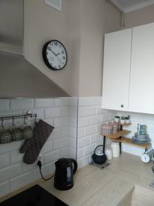 a kitchen with a clock on the wall and a counter at Oksywski bulwar in Gdynia