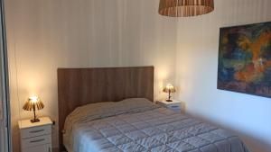 a bedroom with a bed with two night stands and two lamps at Disfruta como local II (dpto) in La Cieneguita