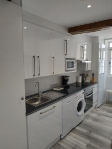 a white kitchen with a sink and a washing machine at RUA NOVA APARTMENT ATICO 3º,a 200m CATEDRAL,PS 4 y NETFLIX in Santiago de Compostela