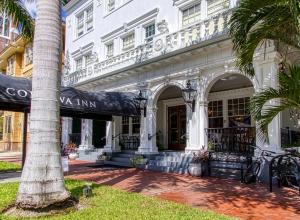 a white building with a palm tree in front of it at New Hotel Collection Downtown St Pete in St Petersburg