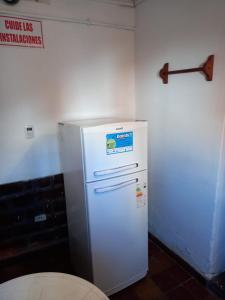 einen weißen Kühlschrank in einer Küche mit einem Schild an der Wand in der Unterkunft Apartamentos Quintana in Santa María