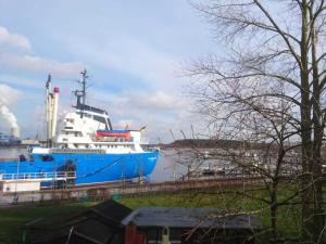 un grand bateau bleu et blanc dans l'eau dans l'établissement Haus Warnowblick Objekt 36737, à Rostock