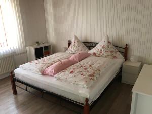 a bed with pink and white sheets and pillows at FeWo Frieda in Salem in Salem