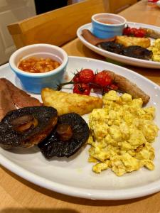 a plate of scrambled eggs and other breakfast foods on a table at Lacet House in Ambleside