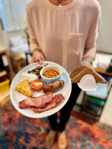 a person holding a plate of breakfast food at Lacet House in Ambleside