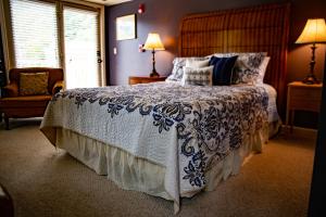 1 dormitorio con 1 cama con edredón azul y blanco en Elk River Hotel & Cafe en Sutton