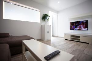 un soggiorno con divano e TV a schermo piatto di CHALET ADOSADO CON TERRAZA Y AZOTEA a Los Realejos