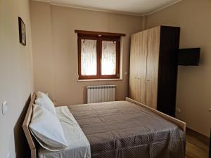 1 dormitorio con cama y ventana en Affittacamere Le Querce, en Teggiano