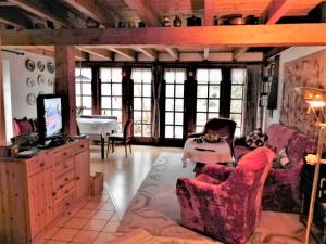 een woonkamer met een bank en stoelen en een tv bij Haus Luise in Homberg