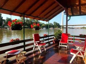 une terrasse couverte avec des chaises et des tables et une vue sur la rivière. dans l'établissement Nature and atractive house, à Belgrade