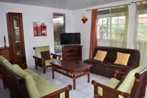 uma sala de estar com um sofá e uma mesa em Villa FRAMBOISINE/ BAYALOCATION em Baréto