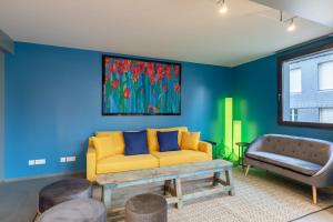 uma sala de estar com um sofá amarelo e uma cadeira em L'Architecte du Cosmopolitain - Design house Jacuzzi- 8 P - Downtown em Honfleur