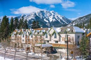 een groot gebouw met sneeuw bedekte bergen op de achtergrond bij The Rundlestone Lodge in Banff