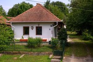 una pequeña casa blanca con techo rojo en Kemencés Vendégház, en Becskeháza