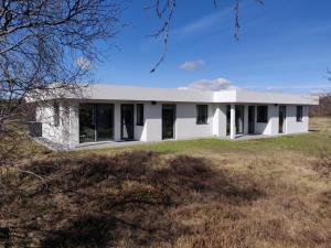 a white house on a grassy field at Mývatn apartments in Myvatn