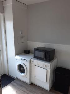 a kitchen with a microwave and a washing machine at Veldzicht in Klarenbeek
