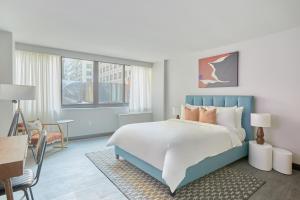 a bedroom with a bed, a desk, and a painting on the wall at Sonder The Quincy in Washington, D.C.