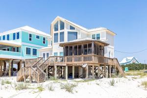 a house on the beach next to the sand at BayWalk by Meyer Vacation Rentals in Fort Morgan