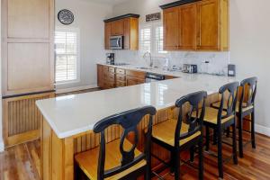 una cucina con piano di lavoro bianco e armadi in legno di Lotsa Dunes by Meyer Vacation Rentals a Fort Morgan