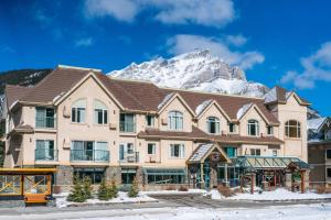 a building with a snow covered mountain in the background at Irwin's Mountain Inn in Banff