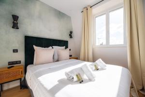 ein Schlafzimmer mit einem großen weißen Bett mit weißen Kissen in der Unterkunft Vignature residence in Asnières-sur-Seine