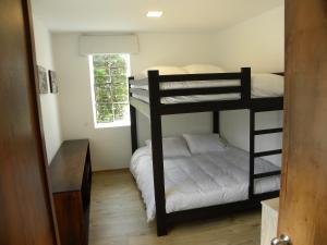 a bedroom with two bunk beds and a window at Hacienda Rosas Pamba in Otavalo