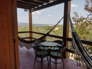 - une terrasse couverte avec un hamac, une table et des chaises dans l'établissement Casa do Rudá na Chapada dos Veadeiros, à Alto Paraíso de Goiás