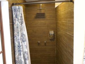 a bathroom with a shower with a shower curtain at Hacienda Rosas Pamba in Otavalo +34 photos