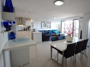 a kitchen and living room with a table and chairs at Blue Coral Terrace Coast Luxury 31 in The Entrance