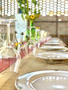 un tavolo in legno con bicchieri da vino e piatti di Casale Viridi - nel fresco delle colline Umbre a Narni