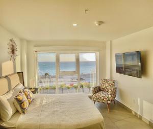 a bedroom with a bed and a view of the ocean at Ocean View Condo overlooking the Caribbean Sea in Oranjestad
