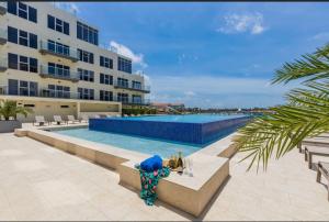 a swimming pool in front of a building at Ocean View Condo overlooking the Caribbean Sea at Harbour House in Oranjestad