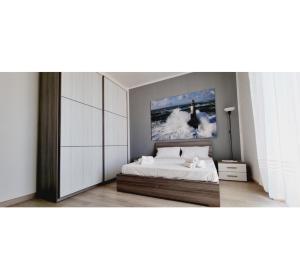 1 dormitorio con 1 cama y una pintura en la pared en La Pepita, en Minturno