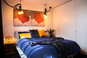 1 dormitorio con 1 cama con sábanas azules y almohadas amarillas en Luxury Cozy 2Bdr Apt WiFi ☆ Netflix ☆Gas Log Fire, en Seaford