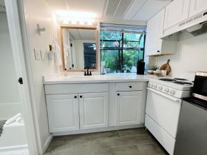 a white kitchen with a sink and a stove at Just Shy of the Bridge - Waterway Condo 110 in Wilmington