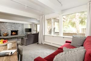 a living room with a red couch and a fireplace at Standard Two Bedroom - Aspen Alps #103 in Aspen