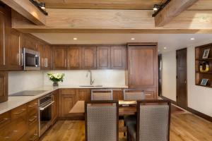 a kitchen with wooden cabinets and a table and chairs at Premier 2 Bedroom - Aspen Alps #104 in Aspen