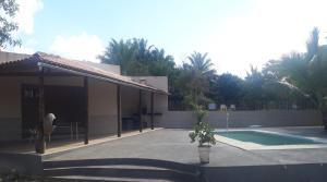 a house with a swimming pool next to a building at Casa temporada Condomínio fechado Praia de Barramares in Ilhéus