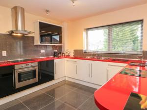 eine Küche mit weißen Schränken und roten Arbeitsplatten in der Unterkunft Mead House in Darlington