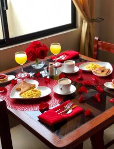 una mesa con platos de comida y vasos de zumo de naranja en Hotel Onix Gold, en Guayaquil