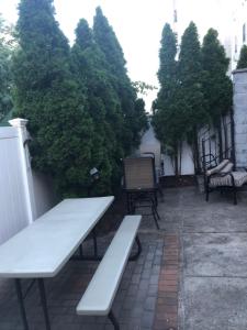 a white bench sitting on a patio with trees at Brooklyn's Finest - Cozy 2 Bedroom in Brooklyn