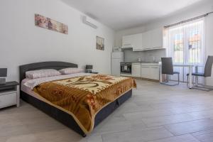 a bedroom with a large bed and a kitchen at Apartment STUDIO in Novi Vinodolski