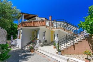 a house with stairs and tables and chairs at Apartment STUDIO in Novi Vinodolski