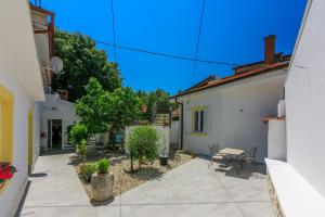 a courtyard of a house with a table and chairs at Apartment STUDIO in Novi Vinodolski +9 photos