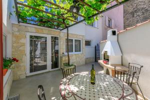 a patio with a table with a bottle of wine at House RUZICA in Novi Vinodolski