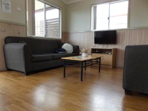 uma sala de estar com um sofá e uma mesa de centro em Birubi Beach Holiday Park em Anna Bay