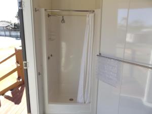 a shower in a bathroom with a shower curtain at Birubi Beach Holiday Park in Anna Bay +50 photos
