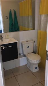 a bathroom with a toilet and a sink and a mirror at Departamento por día ARICA in Arica